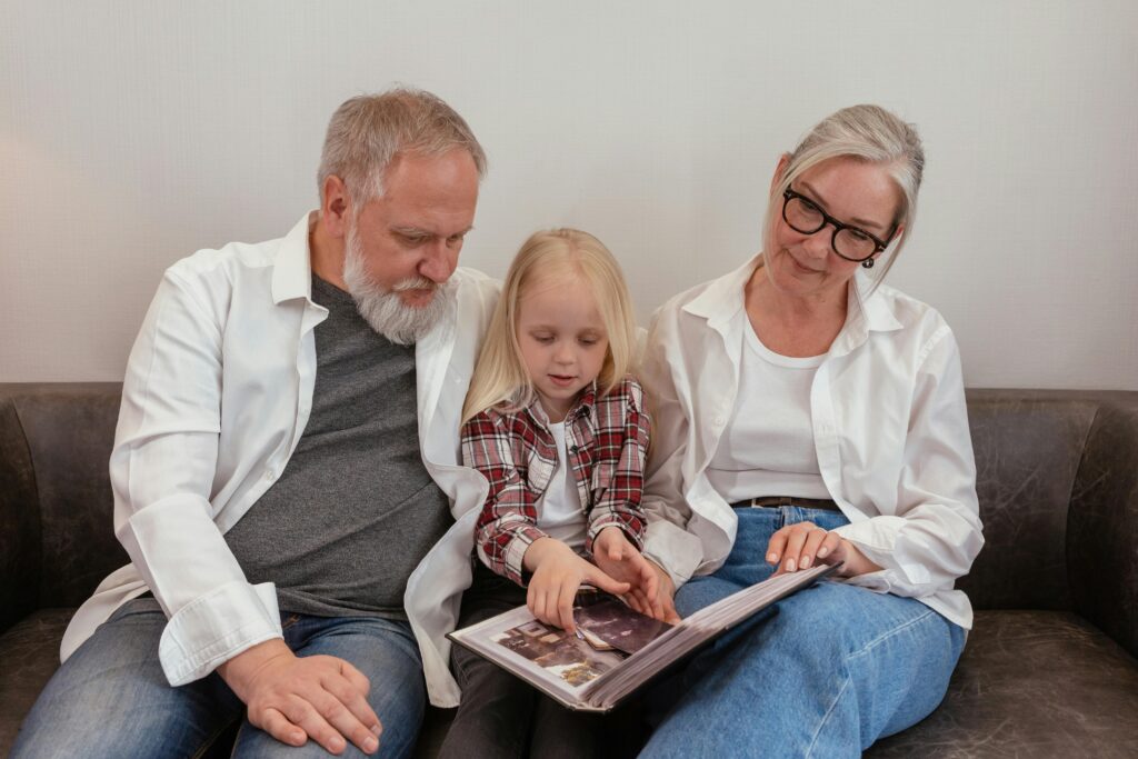 Grandparents sharing with their grandchild the family history in photographs.
