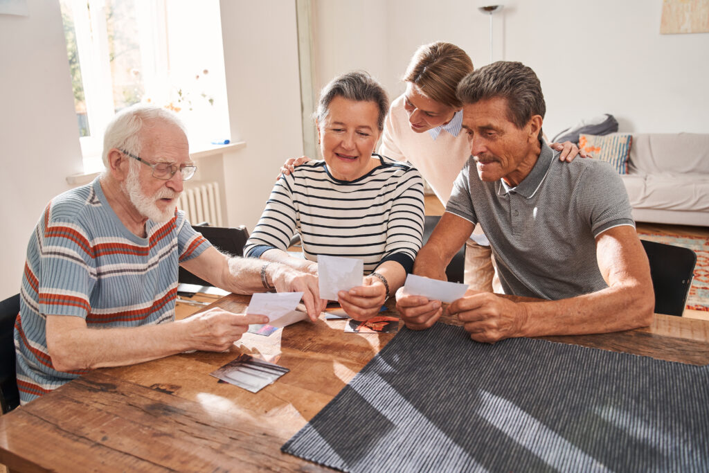 Southern Oregon photo manager's clients capturing stories of older family members while looking at photographs to prompt memories.